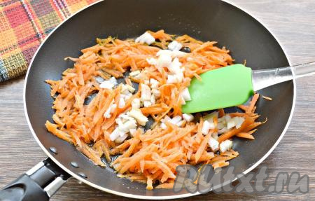 Пока варятся щи с пшеном, приготовим овощную зажарку. Для этого в хорошо разогретую с растительным маслом сковороду нужно выложить очищенную и мелко нарезанную луковицу, добавить небольшую очищенную и натёртую морковку, обжарить овощи на среднем огне 5 минут, периодически перемешивая.