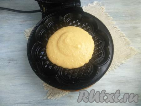 Электровафельницу смазать растительным маслом (верхнюю и нижнюю панели), разогреть в течение 3 минут. Перед тем как набирать тесто, его следует каждый раз перемешивать. Выложить 3 столовые ложки теста, прижать верхнюю панель.
