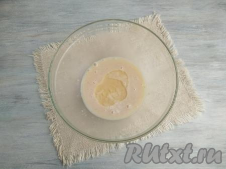 Влить 70 мл тёплого (37 градусов) молока, слегка перемешать массу и оставить минут на 10-15 для активации дрожжей. Через 10-15 минут на поверхности молочно-дрожжевой смеси появятся пузыри и пена - это говорит о том, что дрожжи начали работать. Если поверхность молочно-дрожжевой смеси не запенилась, значит дрожжи следует заменить. В запенившуюся молочно-дрожжевую смесь влить растительное масло, перемешать.