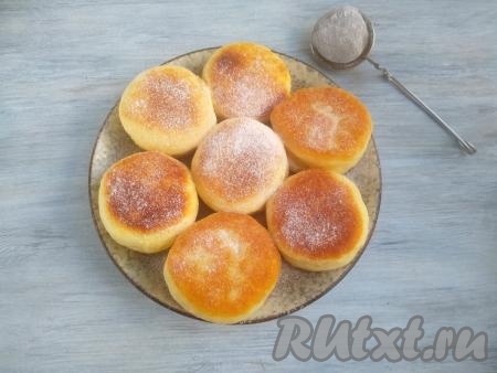 Переложить готовые дрожжевые пышки со сковороды на тарелку, а из оставшегося теста сформировать и пожарить оставшиеся пышки (у меня получилось 7 штук). Остудить пышки, переложить на тарелку для подачи, обильно посыпать сахарной пудрой.