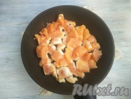 Растительное масло разогреть в сковороде, выложить кусочки куриного мяса и обжарить на среднем огне до золотистого цвета со всех сторон. Не нужно обжаривать мясо до готовности, оно лишь должно покрыться аппетитной корочкой.