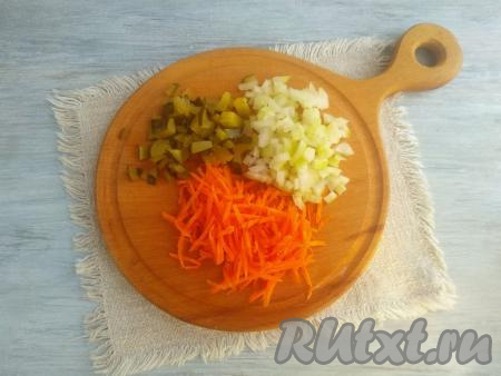 Для приготовления начинки очистить морковь, промыть и натереть на средней тёрке. Солёный огурец нарезать на кубики с размерами сторон чуть меньше 1 см.&nbsp;Отжать нарезанные огурцы от излишков жидкости. Лук очистить, а после этого мелко нарезать.