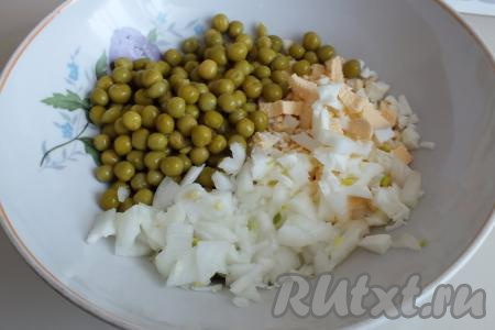 2 яйца отварите в течение минут 8-10 с момента закипания воды, затем дайте им остыть и очистите от скорлупы, мелко нарежьте (или натрите на крупной тёрке). В достаточно объёмный салатник выложите консервированный горошек, нарезанные лук и яйца.