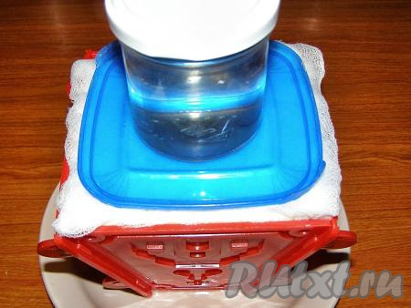 Через час ставим поверх формы с творожной заварной пасхой небольшой груз и убираем в холодильник на 12-14 часов. Сыворотку, которая будет стекать в тарелку, периодически нужно аккуратно сливать.