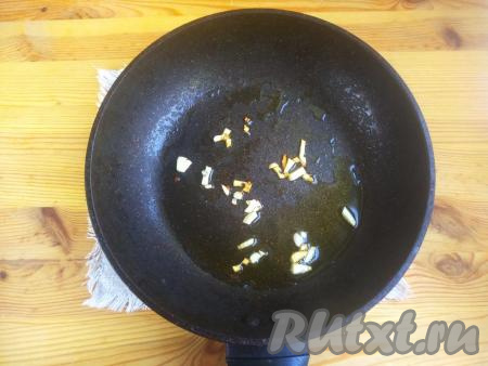 На сковороду вылить оливковое (или подсолнечное) масло, выложить чеснок. Обжарить кусочки чеснока на среднем огне в течение 30 секунд, чтобы появился характерный запах чеснока.