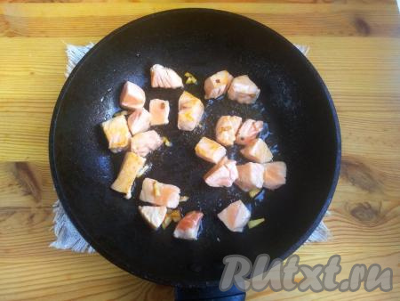 Добавить кусочки сёмги и жарить, иногда помешивая, на среднем огне около 2 минут (рыбка должна побелеть со всех сторон).