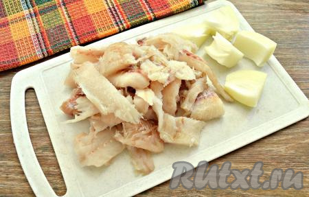 Удалить хребтовую кость и мелкие косточки. Разделать тушку минтая на филе. А затем рыбное филе нарезать на кусочки для дальнейшего измельчения в мясорубке. Очистить половинку лука, нарезать его крупными дольками.