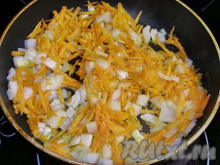 Теперь приготовим томатно-сметанный соус. В сковородку с подсолнечным маслом выкладываем 1 очищенную луковицу, нарезанную на кубики среднего размера, и очищенную морковку, заранее натёртую на крупной тёрке, обжариваем, иногда помешивая, 4-5 минут (до мягкости овощей) на среднем огне.