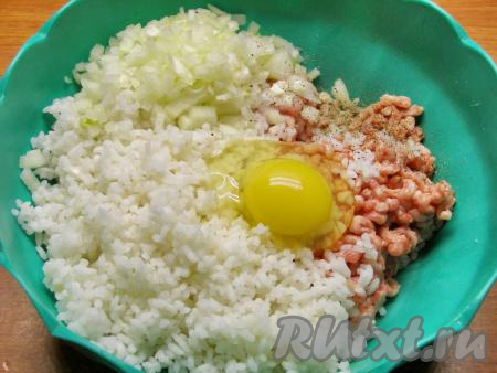 Мясной фарш выкладываем в достаточно объёмную миску, добавляем 1 очищенную и мелко нарезанную луковицу, остывший рис и сырое яйцо, солим и перчим по вкусу. Перемешиваем, чтобы все ингредиенты равномерно распределились по всему фаршу.