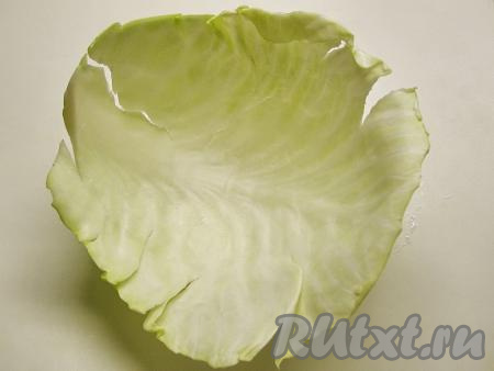 Надрезаем капусту около кочерыжки. А затем аккуратно, стараясь не порвать капустные листы, отделяем их от кочана.