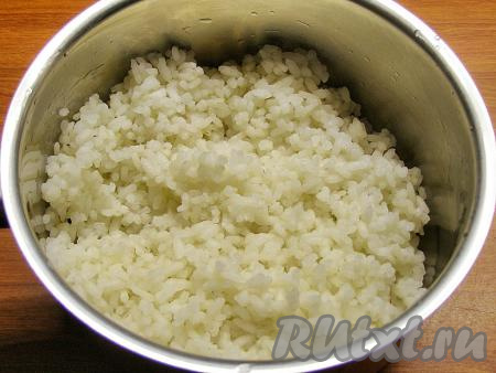 В отдельной кастрюльке кипятим достаточно большое количество воды, подсаливаем закипевшую воду и выкладываем хорошо промытый рис, варим с момента закипания на небольшом огне 20-25 минут (до готовности риса). После чего воду сливаем, рис оставляем остывать.