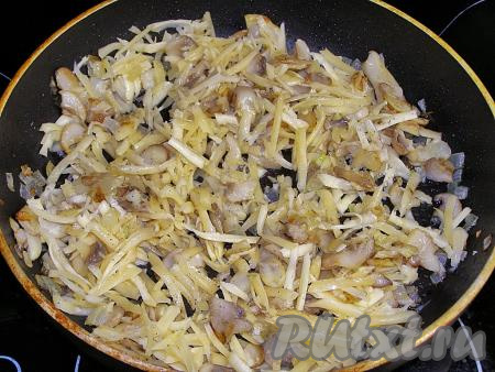 В тёплые грибы кладём натёртый сыр и перемешиваем. По вкусу начинку можно немного посолить и поперчить.