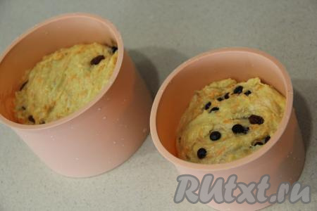 Вмешать изюм и шоколад в тесто. Разделить тесто на две части и выложить в формы, заполняя их чуть больше, чем на половину.&nbsp;