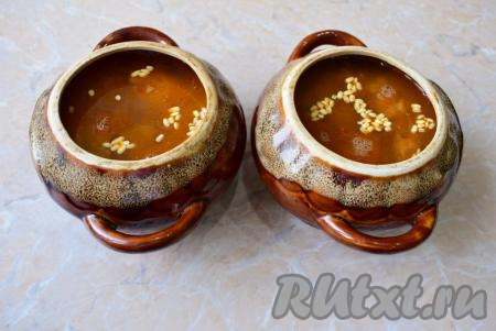 Залейте содержимое горшочков горячей водой так, чтобы она была немного выше уровня перловки, но не доходила до верха горшочков, подсолите. Добавьте в каждый горшочек по 1 мелко нарезанному зубчику чеснока.