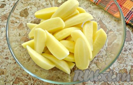 Картофель очистить, ополоснуть холодной водой, нарезать крупными ломтиками и выложить в объёмную миску.