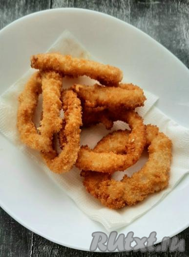 В тарелку положить несколько бумажных салфеток, выкладывать готовые кольца на салфетки, чтобы впиталось лишнее масло. Постепенно пожарить все колечки.