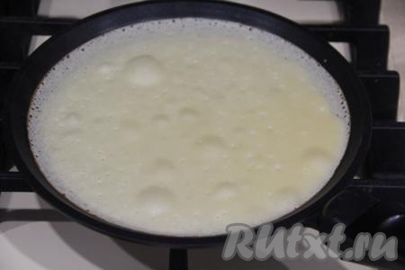 На хорошо разогретую сковороду (я её смазала маслом только перед жаркой первого блина) наливать часть теста, равномерно распределяя его по дну сковородки.