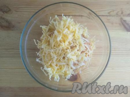 Сыр натереть на средней тёрке. Половину натёртого сыра выложить в миску к фаршу.