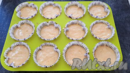 Тесто распределяем по формам. Я использовала бумажные формочки для кексов, вставив их в силиконовую форму. Если будете использовать металлические формы, то обязательно смажьте их растительным маслом. Заполняем формы, примерно, на 2/3 объёма (больше половины). Отправляем в разогретую до 180 градусов духовку. Выпекаем апельсиновые кексы 25-30 минут.