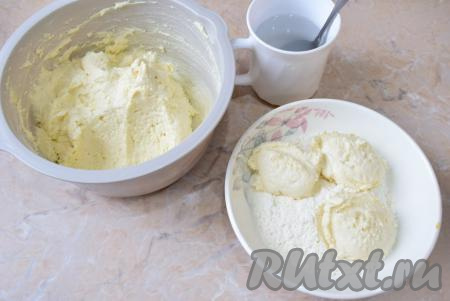 В отдельную миску насыпьте муку, в которой будете обваливать заготовки сырников. Мокрой столовой ложкой выкладывайте творожное тесто&nbsp;в муку и немного обваливайте со всех сторон. Затем руками продолжите обваливание в муке, формируя&nbsp;небольшие сырники округлой формы. Благодаря такой мучной панировке, наши сырники будут хорошо держать форму и не развалятся во время жарки. При этом консистенция у сырников из творожного сыра будет нежной, так как в само тесто мы добавили небольшое количество муки (тесто не забили&nbsp;мукой).