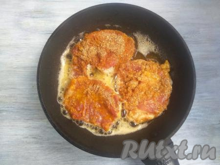 На сковороде раскалить сливочное и растительное масло, затем выложить кусочки свинины в панировке и жарить с одной стороны в течение 3-4 минут (до золотистой корочки) на среднем огне.