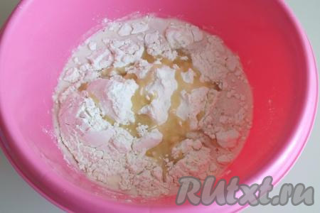 По истечении времени в запенившуюся дрожжевую смесь всыпьте соль, половину указанного количества муки и половину указанного количества масла, перемешайте ложкой. Получится жидкое тесто.