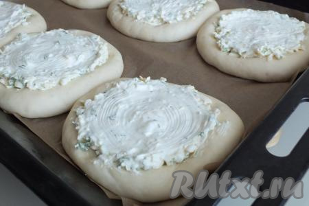 Смажьте начинку сметаной (на смазывание 6 шанег потребуется 2 столовые ложки с горкой сметаны) и оставьте на 10 минут. За это время разогрейте духовку до 180 градусов. Через 10 минут поставьте противень с шаньгами с сыром и яйцами выпекаться в течение 25-30 минут.