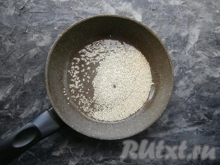 Затем в сковороде хорошо разогреть растительное масло, всыпать кунжут и обжарить его, помешивая, около 20 секунд. Как только кунжут начнёт изменять цвет на золотистый - убрать его с огня.