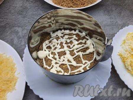 Сверху выложить половину натёртой печени, слегка утрамбовать с помощью ложки, нанести немного смеси майонеза и чеснока.