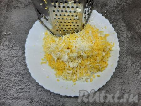 Яйца нужно сварить заранее (варим минут 8-9 с момента закипания воды, затем даём им полностью остыть и очищаем от скорлупы). Варёные яйца натереть в отдельную тарелку на мелкой тёрке.