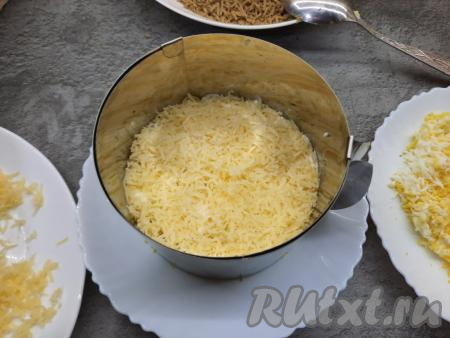 На слой печени с майонезом выложить половину натёртого сыра. Майонез с чесноком на слой сыра наносить не нужно.