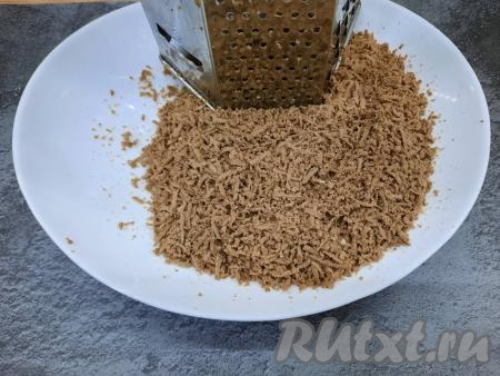 Остывшую варёную говяжью печень тоже натереть в отдельную ёмкость на мелкой тёрке. И яйца, и печёнку, и сыр нужно натирать именно на одной и той же тёрке с мелкими отверстиями, тогда салат получится нежным. Натирать ингредиенты нужно на разные тарелки, потому что блюдо будет выкладываться слоями.