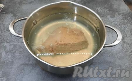 В кастрюле вскипятить воду, поместить в кипящую воду говяжью печень, очищенную от плёнки, и варить 20-25 минут. За 10 минут до готовности добавить соль. Готовность печени можно проверить следующим образом: прокалываем вилкой печень и надавливаем на неё, если из проколов выделяется прозрачный сок, значит печёнка готова, а если выделяется красный (или розовый сок), то варим ещё 5-10 минут.  Готовую печень достать из воды и полностью остудить.