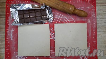 Бездрожжевое слоёное тесто разморозить при комнатной температуре (у меня тесто размораживалось 1,5 часа). Можно заранее достать слоёное тесто из морозилки и положить в холодильник, чтобы им можно было воспользоваться с утра. В моей упаковке было 2 пластины теста. Шоколад поломать (или нарезать ножом) на мелкие кусочки.