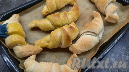 По прошествии 20 минут круассаны достать из духовки, с помощью кисточки&nbsp;смазать их яично-сахарной смесью и вернуть в духовку ещё на 5-7 минут.