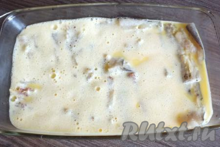 Филе минтая с овощами залейте омлетной смесью.