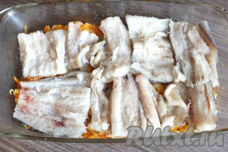 Когда морковка с луком станут мягкими, переложите их на дно формы&nbsp;для запекания, дайте немного остыть. Филе минтая нарежьте на кусочки, посолите и приправьте по вкусу чёрным молотым перцем, а затем выложите поверх овощей.