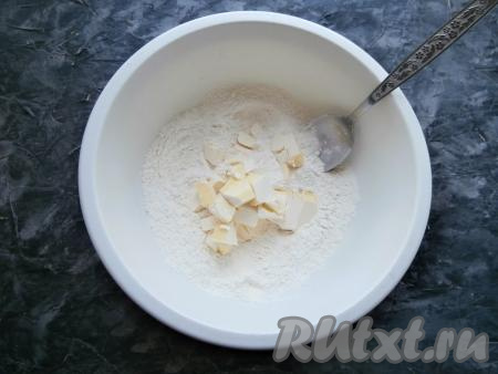 В мучную смесь выложить кусочки размягчённого сливочного масла (для того чтобы масло размягчилось, его нужно заранее достать из холодильника, чтобы оно согрелось и стало мягким при комнатной температуре).