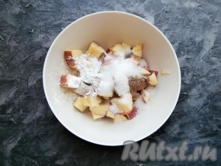 Теперь приготовим начинку крамбла, для этого яблоки, предварительно удалив из них сердцевины, нужно нарезать средними кубиками, затем всыпать к ним сахар, корицу и крахмал, перемешать.