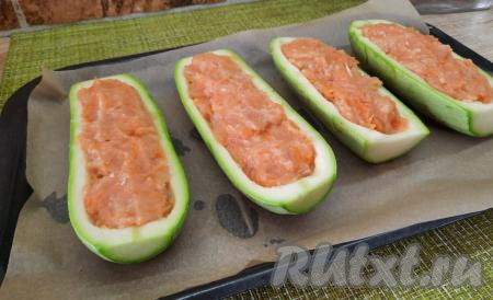 Получившимся куриным фаршем наполнить кабачковые лодочки, выкладывая фарш ложкой в углубления. Фаршированные лодочки выложить на противень, застеленный пергаментом, и отправить минут на 30 в духовку, разогретую до 180 градусов.
