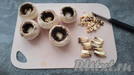 Аккуратно отделить ножки шампиньонов от шляпок. Ножки мелко нарезать.
