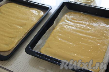 Застелить 2 противня (у меня размер противней 40 см х 50 см) пергаментом, затем выложить тесто на противни, распределяя его равномерно.