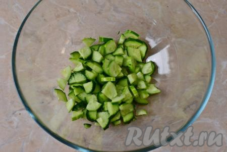 Огурец помойте, обсушите, разрежьте вдоль на 4 части, затем нарежьте тонкими ломтиками.