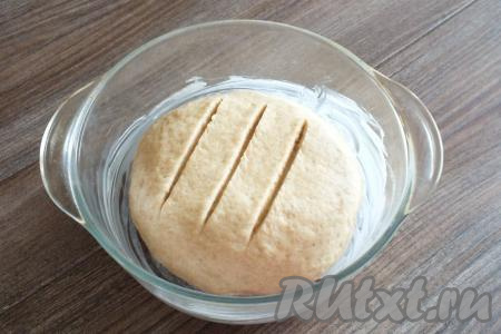 Возьмите форму для выпечки, смажьте её сливочным маслом. Из теста сформируйте шар и выложите его в форму. На поверхности шара сделайте 3 разреза острым ножом, прикройте полотенцем и оставьте в тепле&nbsp;на 30 минут.