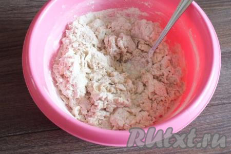 Начните замес теста, перемешивая получившуюся массу ложкой. Как только тесто начнёт собираться в комочки, продолжите замешивать руками.