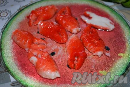 Клешни достаём из масляной заливки и разрезаем их пополам, так как они крупные.