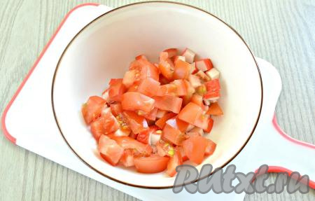 Промываем свежие помидоры, вырезаем плодоножку. Для этого салата лучше использовать упругие, спелые помидоры с минимальным содержанием мякоти. Нарезаем помидоры небольшими кусочками, добавляем в салатник с крабовыми палочками.