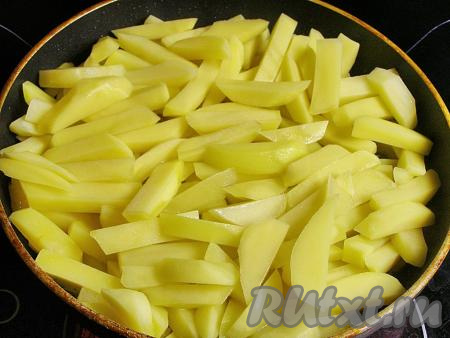 В другую сковородку наливаем 100 мл подсолнечного масла, сильно его разогреваем и выкладываем картофельные ломтики. Оставляем жариться на среднем огне, не накрывая сковородку крышкой, в течение минут 10, не добавляя соль и не перемешивая.