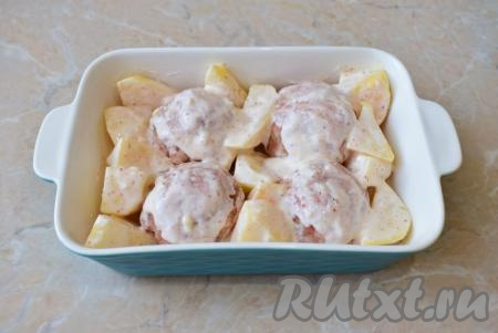 Между мясными шариками разложите дольки картошки, покрытые сметаной. Оставшимся сметанным соусом смажьте сверху шарики. Поставьте форму в духовку, разогретую до 180 градусов, на 40-45 минут.