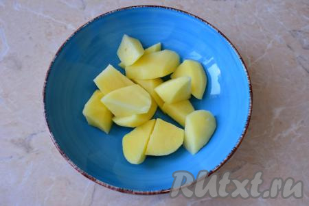 Картофель очистите от кожуры и ополосните водой, нарежьте на крупные кусочки, переложите в тарелку.